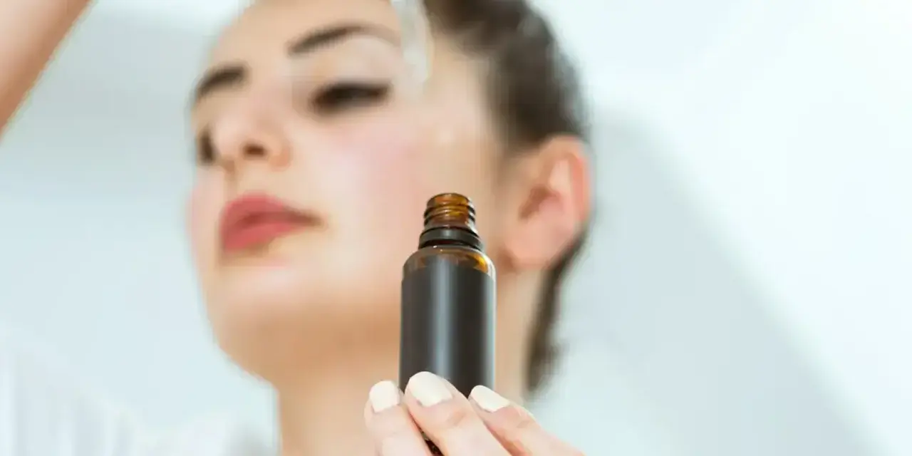 Kobieta aplikuje serum na twarz. Odkryj zachwycające ozonowanie twarzy efekty dla promiennej cery.