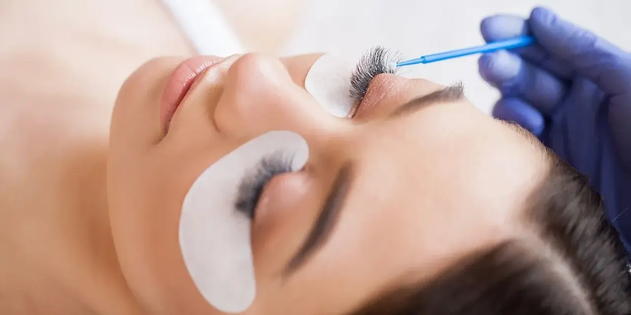 Stylistka aplikuje preparat na rzęsy. To nie jest co to henna, ale zabieg przedłużania rzęs.