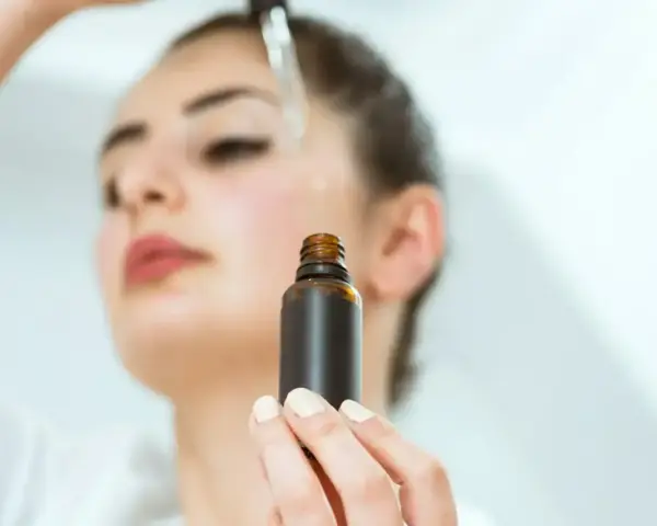 Kobieta aplikuje serum na twarz. Odkryj zachwycające ozonowanie twarzy efekty dla promiennej cery.
